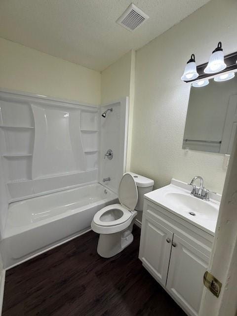 bathroom with visible vents, toilet, a textured ceiling, wood finished floors, and shower / bathtub combination