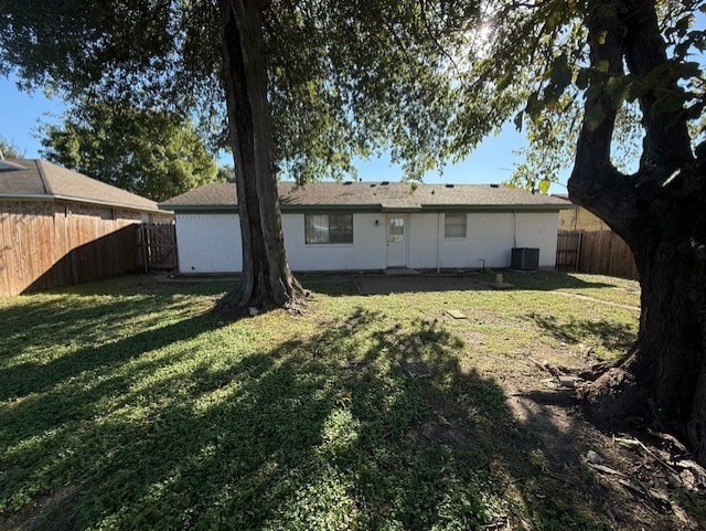 back of property with a lawn, cooling unit, and a fenced backyard