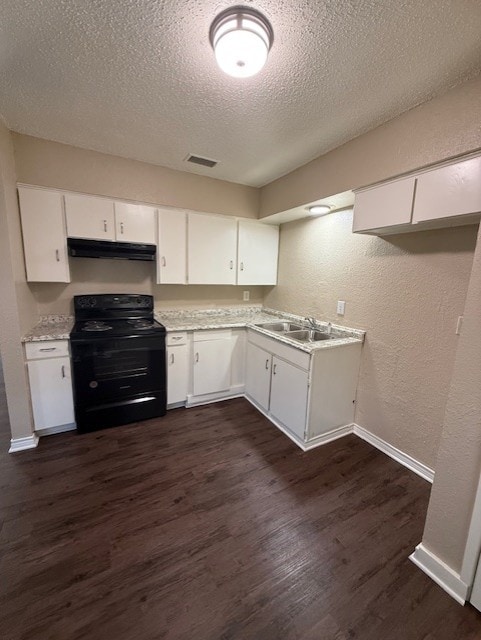 kitchen with under cabinet range hood, electric range, dark wood-type flooring, and a textured wall