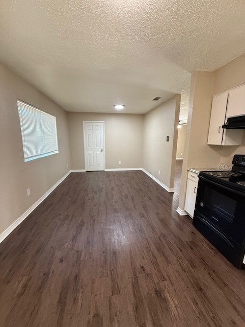 unfurnished living room with visible vents, baseboards, dark wood-type flooring, and a textured ceiling