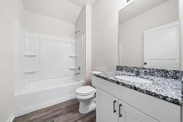 full bathroom featuring toilet, vanity, bathing tub / shower combination, and wood finished floors