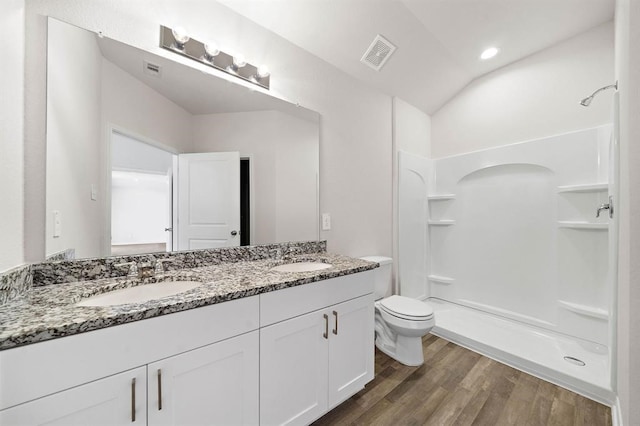 bathroom with a stall shower, wood finished floors, visible vents, and a sink