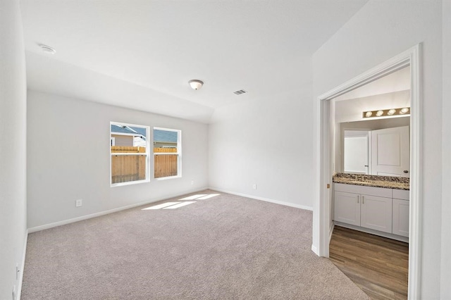 unfurnished bedroom featuring visible vents, carpet floors, baseboards, and connected bathroom