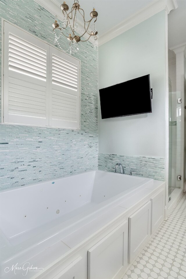 full bathroom featuring an inviting chandelier, a jetted tub, crown molding, and a stall shower