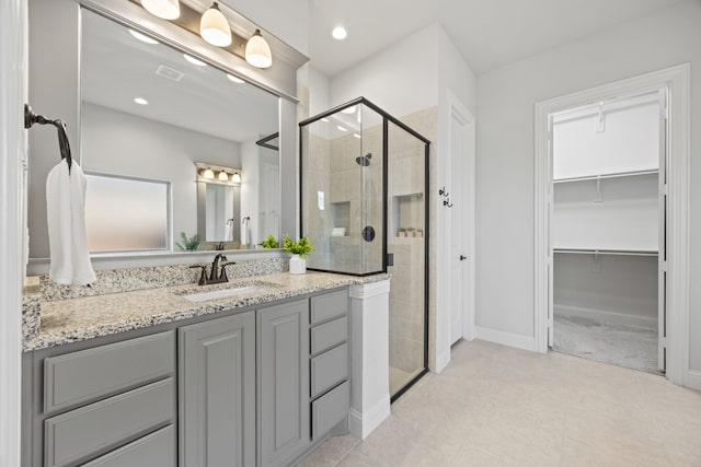 bathroom with vanity, visible vents, recessed lighting, a shower stall, and a walk in closet