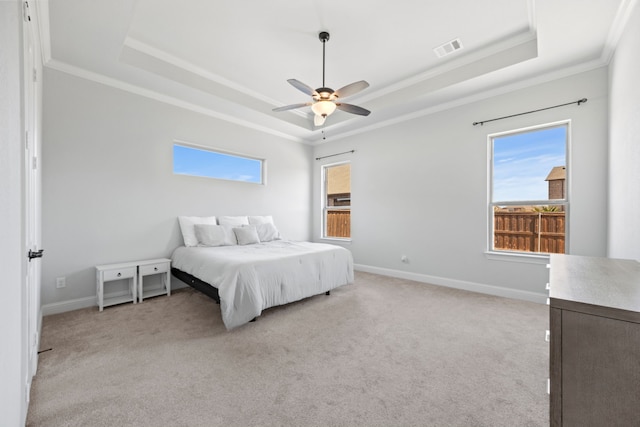 bedroom featuring baseboards, visible vents, a tray ceiling, ornamental molding, and light colored carpet