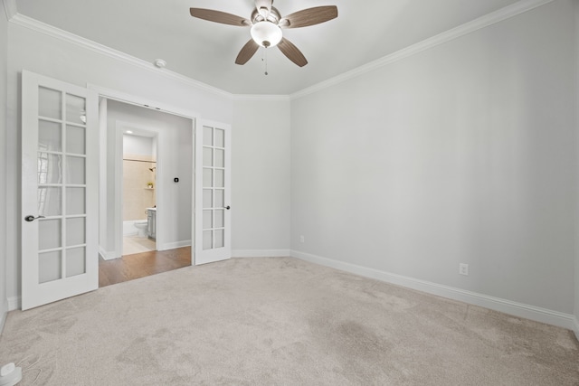 carpeted spare room featuring french doors, baseboards, and ornamental molding