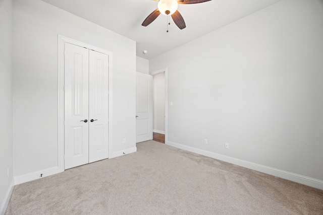 unfurnished bedroom with a closet, carpet flooring, a ceiling fan, and baseboards