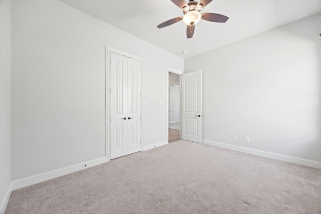 unfurnished bedroom with a closet, carpet floors, baseboards, and ceiling fan