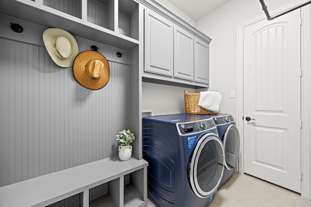 washroom with cabinet space, light tile patterned floors, and washing machine and dryer