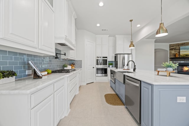 kitchen featuring appliances with stainless steel finishes, light tile patterned flooring, and white cabinetry