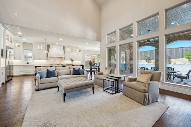 living area featuring dark wood-type flooring, a healthy amount of sunlight, and visible vents