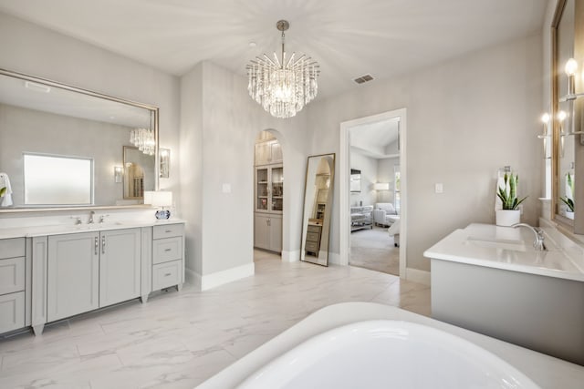 full bath featuring visible vents, a freestanding bath, an inviting chandelier, marble finish floor, and vanity