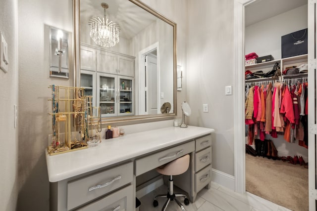 bathroom with an inviting chandelier and baseboards