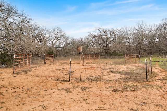 view of yard featuring a gate, a rural view, and fence