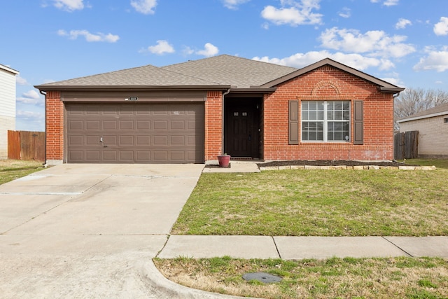 ranch-style home with a front yard, fence, driveway, an attached garage, and brick siding