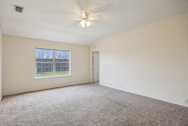 spare room featuring visible vents, a textured ceiling, carpet, lofted ceiling, and ceiling fan