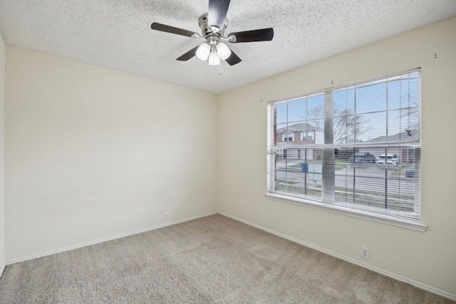 unfurnished room with ceiling fan, carpet, baseboards, and a textured ceiling