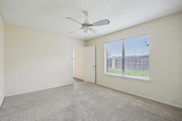 empty room featuring ceiling fan, baseboards, carpet floors, and a textured ceiling