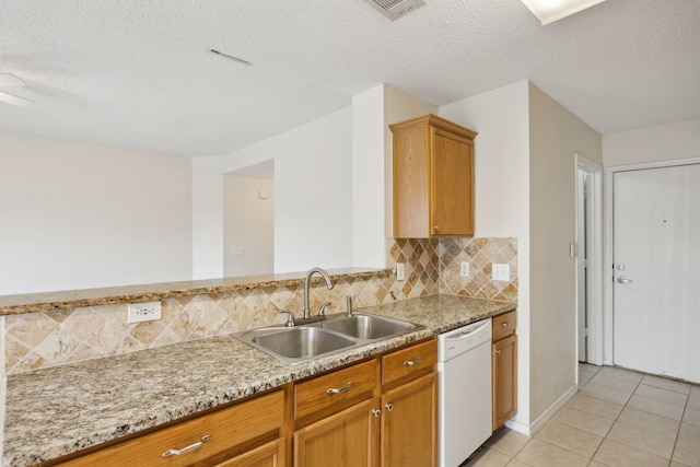 kitchen with visible vents, light tile patterned flooring, white dishwasher, a sink, and backsplash