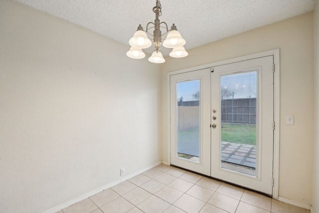 doorway to outside featuring a notable chandelier, a textured ceiling, french doors, light tile patterned floors, and baseboards