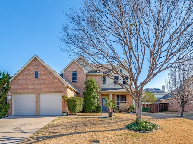 traditional-style house featuring driveway, a front lawn, fence, a garage, and brick siding