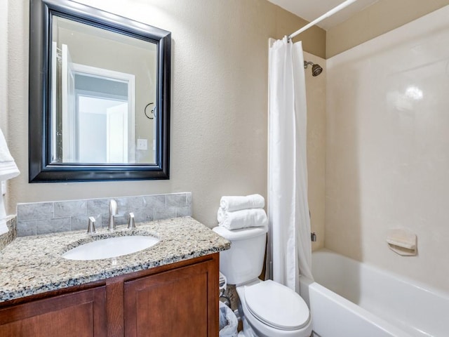 bathroom featuring toilet, shower / bath combo, vanity, and a textured wall