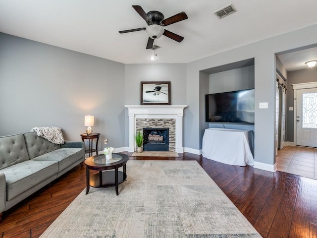 living area featuring visible vents, ceiling fan, baseboards, and hardwood / wood-style flooring