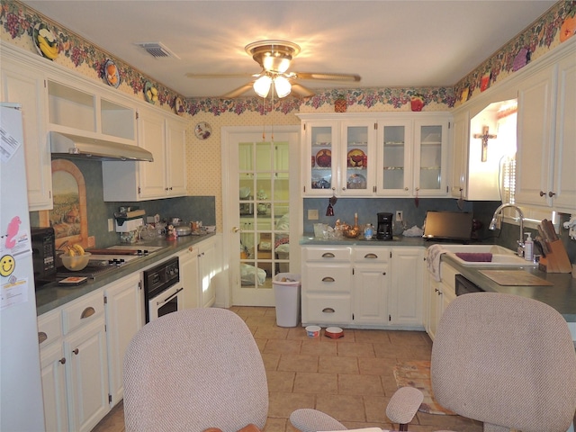 kitchen with visible vents, under cabinet range hood, white cabinets, white appliances, and a sink