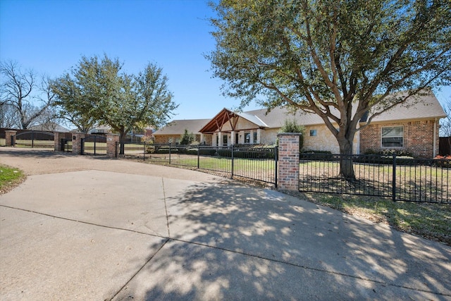 view of front of house featuring a gate, brick siding, and a fenced front yard