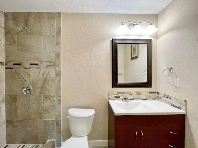 full bath with toilet, a tile shower, decorative backsplash, a textured wall, and vanity