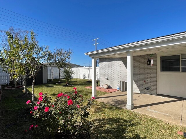 view of yard featuring a storage unit, central AC, a fenced backyard, an outdoor structure, and a patio area