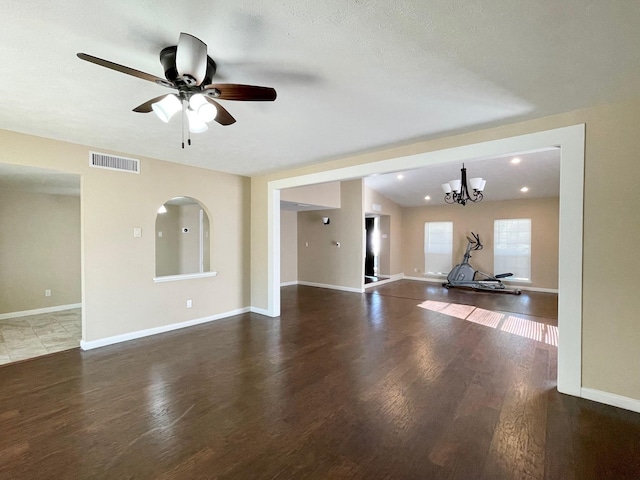 unfurnished living room with visible vents, baseboards, and wood finished floors