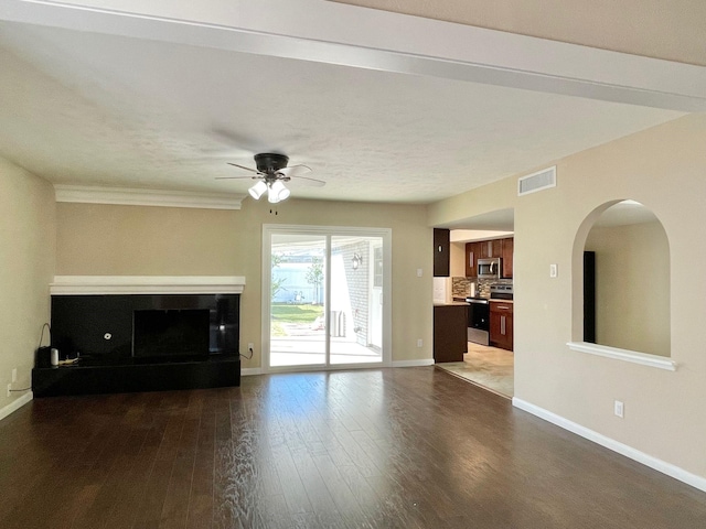 unfurnished living room featuring a ceiling fan, dark wood-type flooring, visible vents, and baseboards