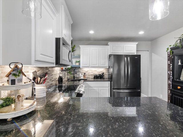 kitchen with a sink, stainless steel appliances, backsplash, and white cabinetry