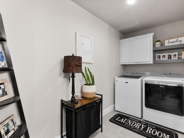 laundry room with washer and dryer, baseboards, cabinet space, and light tile patterned floors