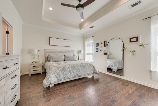 bedroom featuring a tray ceiling, visible vents, ornamental molding, and dark wood-style flooring