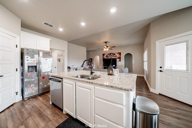 kitchen featuring visible vents, arched walkways, a sink, stainless steel appliances, and white cabinetry
