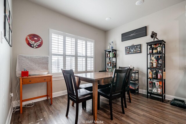 dining space featuring baseboards and wood finished floors