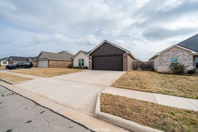 ranch-style home with fence, an attached garage, concrete driveway, board and batten siding, and brick siding