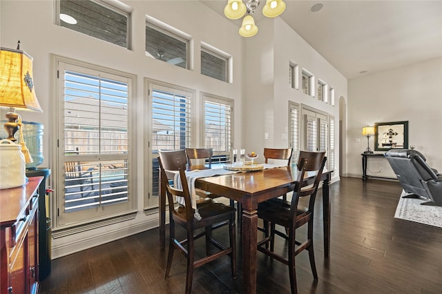 dining space with a high ceiling and dark wood-style flooring