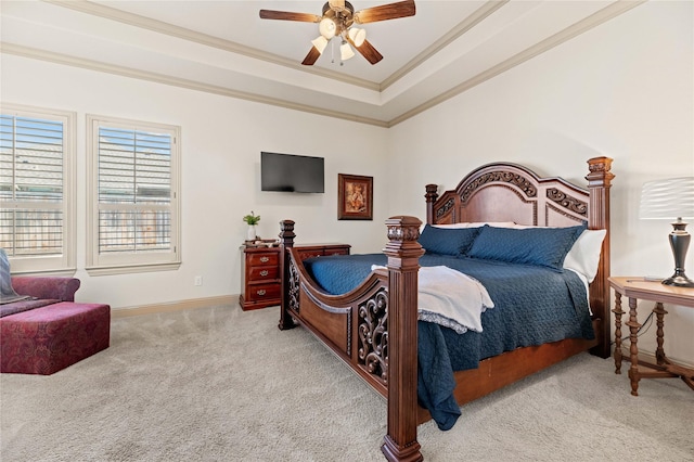 bedroom featuring crown molding, ceiling fan, baseboards, a tray ceiling, and carpet floors