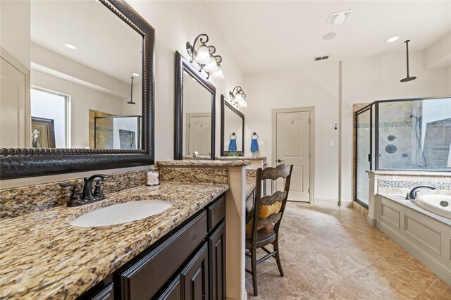 bathroom featuring vanity, a shower stall, a garden tub, and visible vents