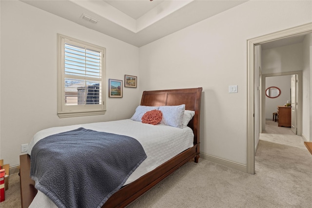 bedroom featuring visible vents, light carpet, and baseboards