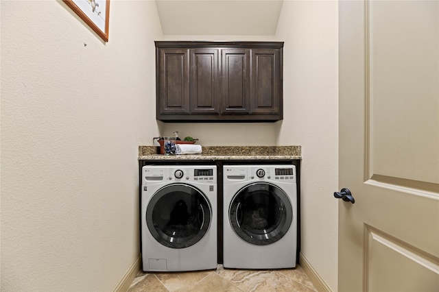 clothes washing area with cabinet space, independent washer and dryer, and baseboards