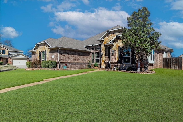 view of front of home featuring brick siding, a shingled roof, fence, a front yard, and stone siding