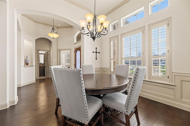 dining room with plenty of natural light, dark wood-style floors, and ornamental molding