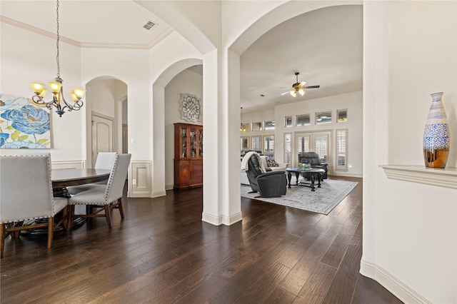 dining room featuring dark wood-style floors, visible vents, ceiling fan with notable chandelier, and a high ceiling