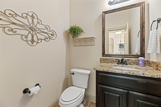 bathroom with vanity, toilet, and baseboards