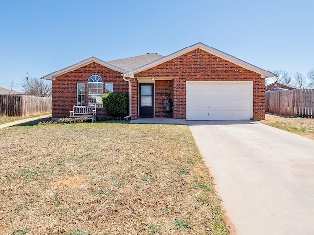 ranch-style home featuring driveway, brick siding, an attached garage, and fence